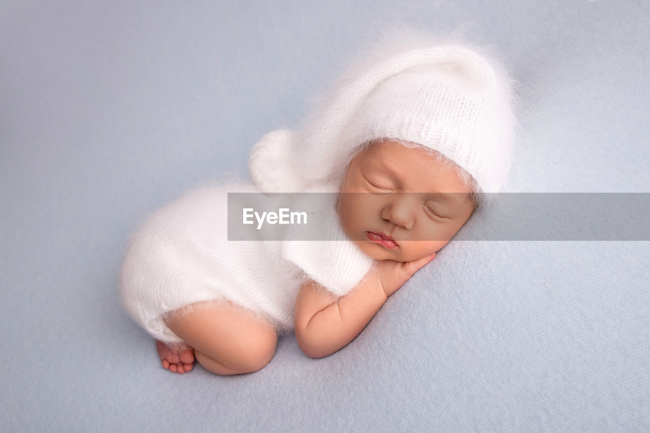 high angle view of cute baby boy sleeping on bed at home