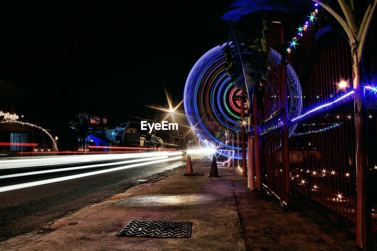 ILLUMINATED LIGHT TRAILS ON ROAD IN CITY