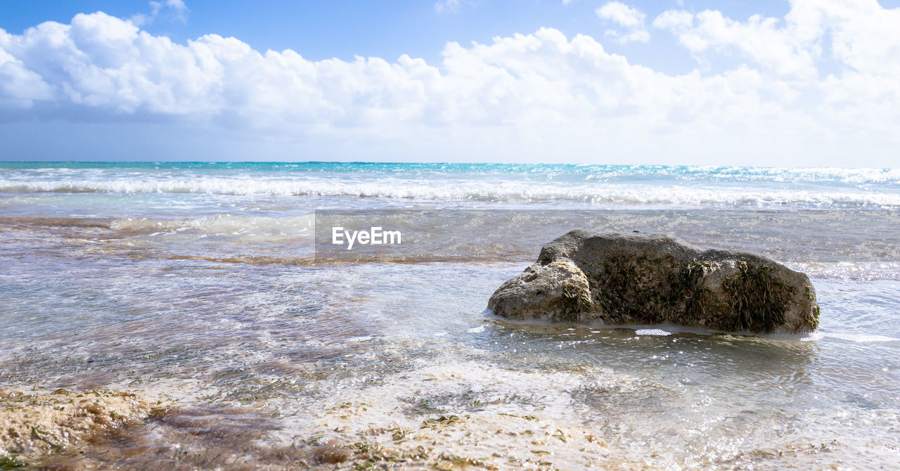 ROCKS ON BEACH AGAINST SKY