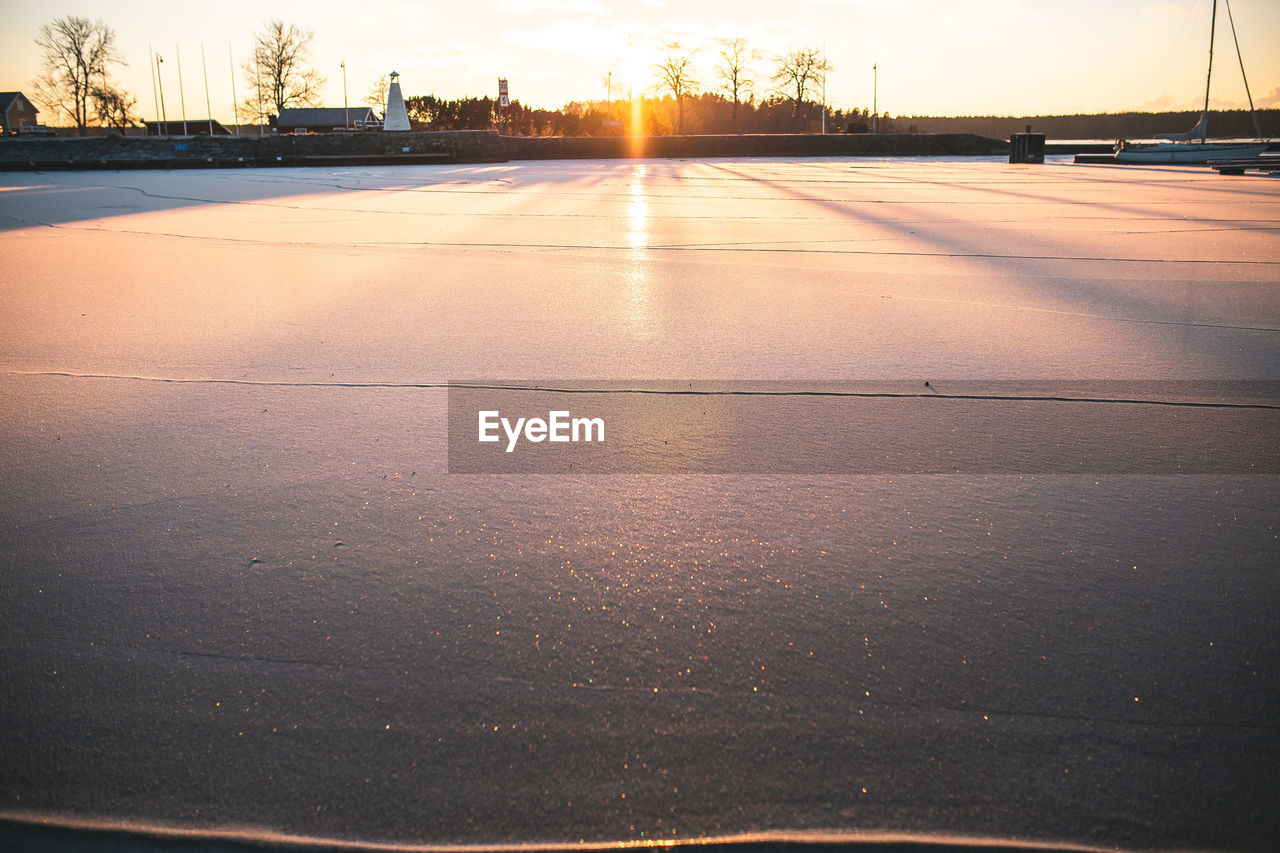 sunset, reflection, sky, evening, dusk, sunlight, nature, horizon, light, transportation, no people, sun, road, cloud, water, winter, outdoors, city, architecture, environment, sea, sports, cold temperature, landscape, tranquility