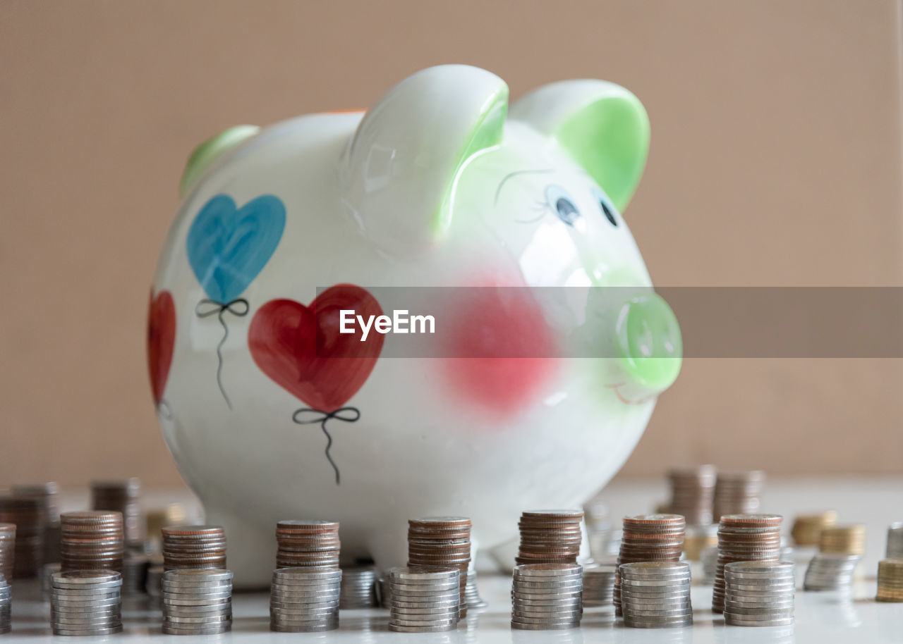 Piggy bank by coins on table