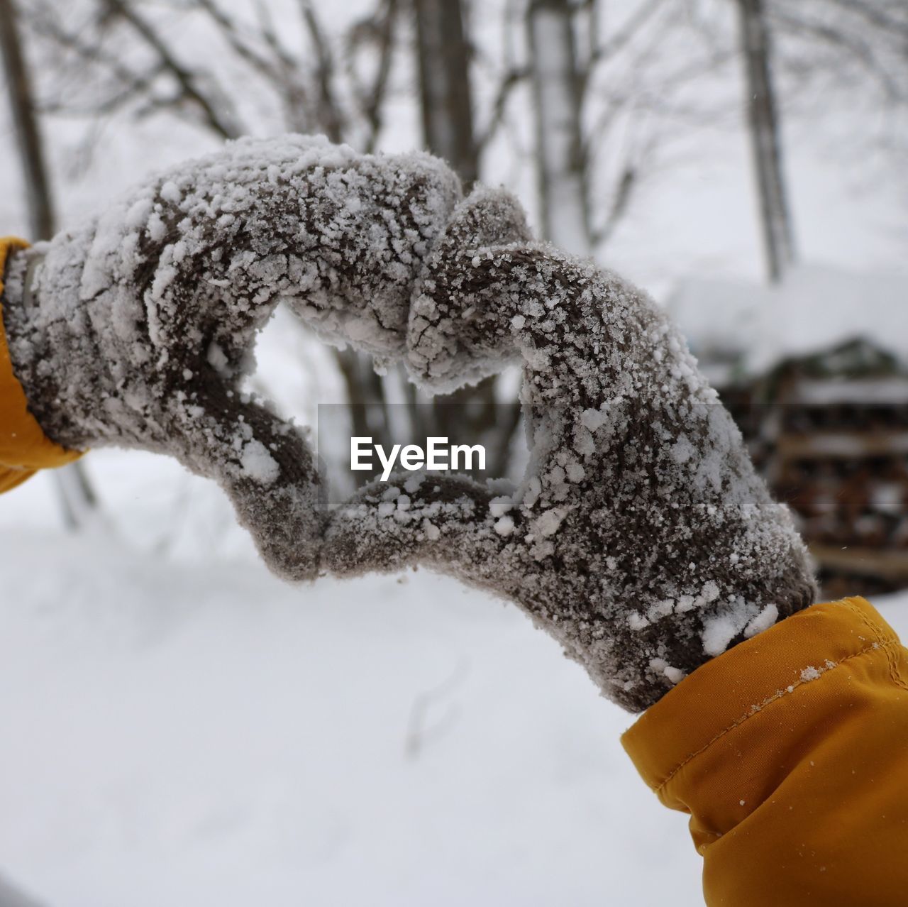 Cropped hands making heart shape during winter