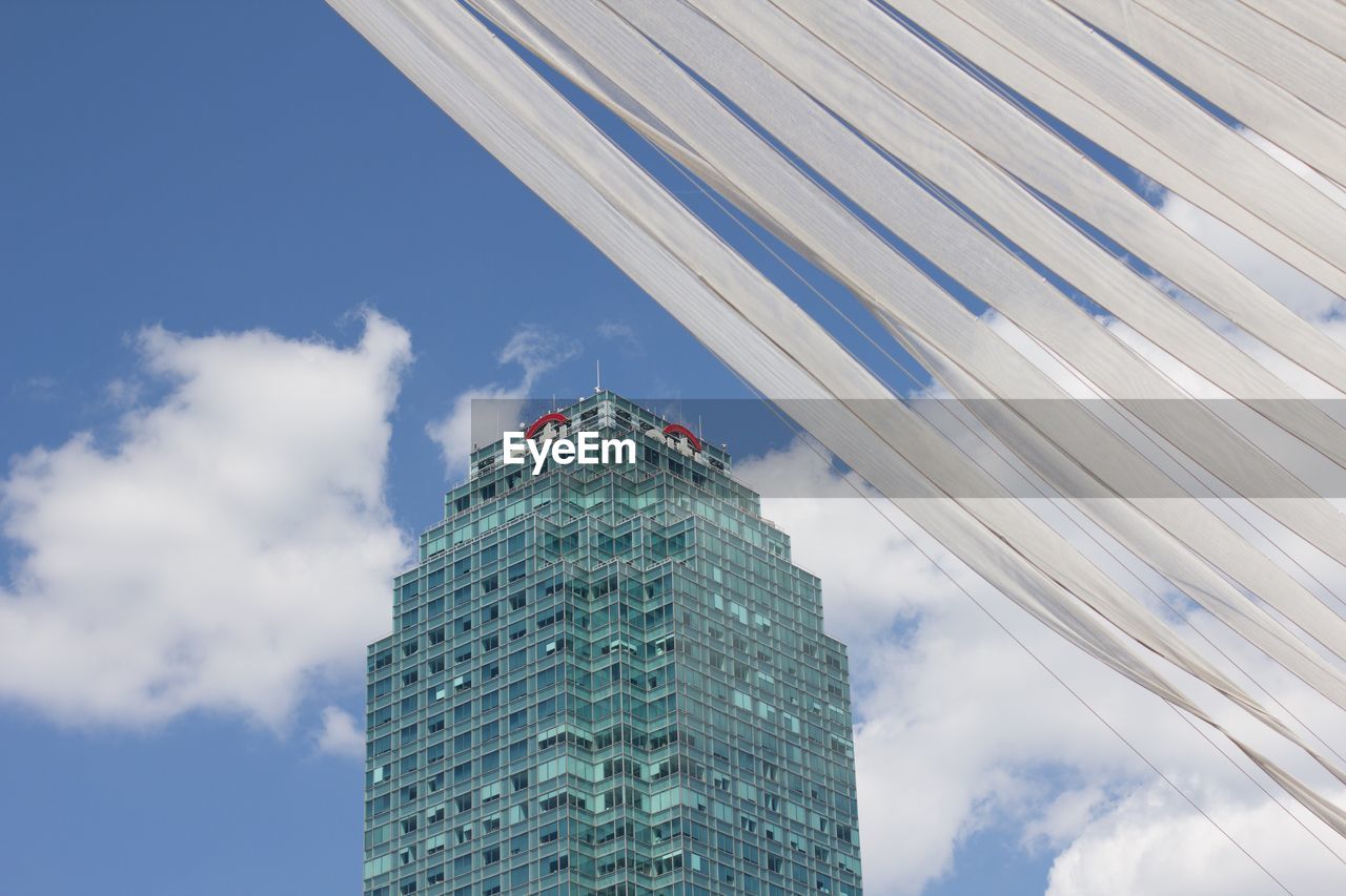 LOW ANGLE VIEW OF MODERN BUILDINGS AGAINST CLOUDY SKY