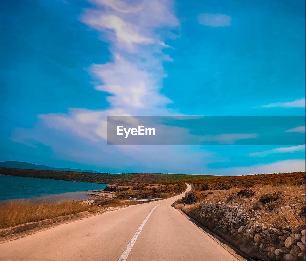 Empty road along landscape and blue sky