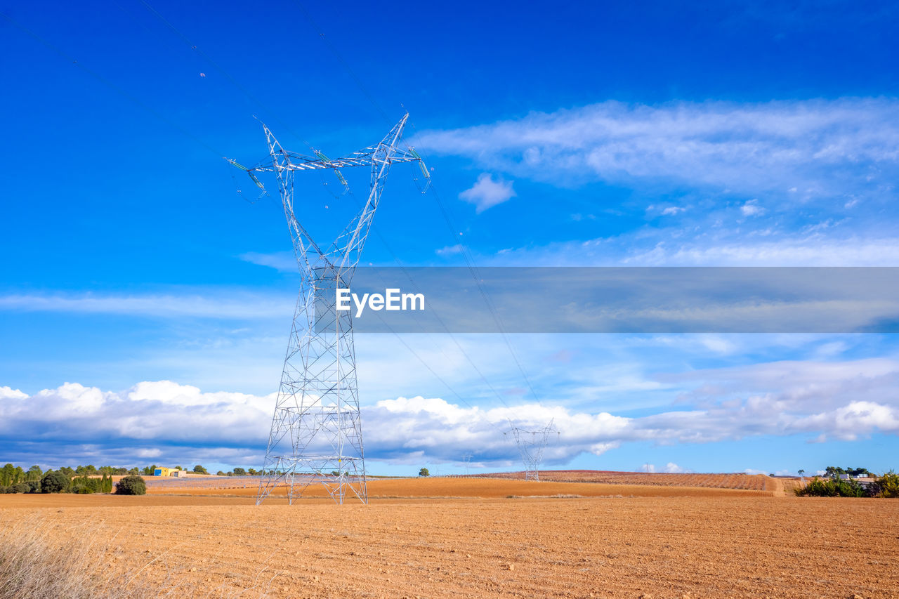 sky, horizon, landscape, environment, technology, cloud, electricity, land, field, nature, blue, power generation, electricity pylon, rural scene, cable, agriculture, wind, power supply, prairie, scenics - nature, no people, plant, plain, beauty in nature, power line, horizon over land, outdoors, day, transmission tower, farm, grassland, cereal plant, crop, overhead power line, tranquility, architecture, tree, non-urban scene, tower, built structure, tranquil scene