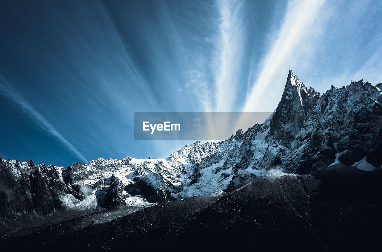 Low angle view of snowcapped mountains against sky