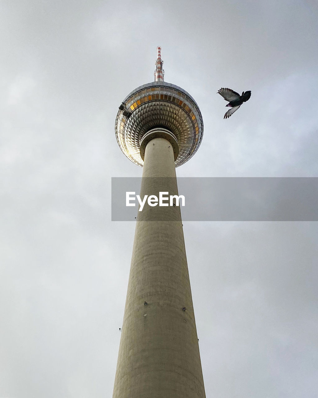 LOW ANGLE VIEW OF COMMUNICATIONS TOWER AGAINST CLOUDY SKY