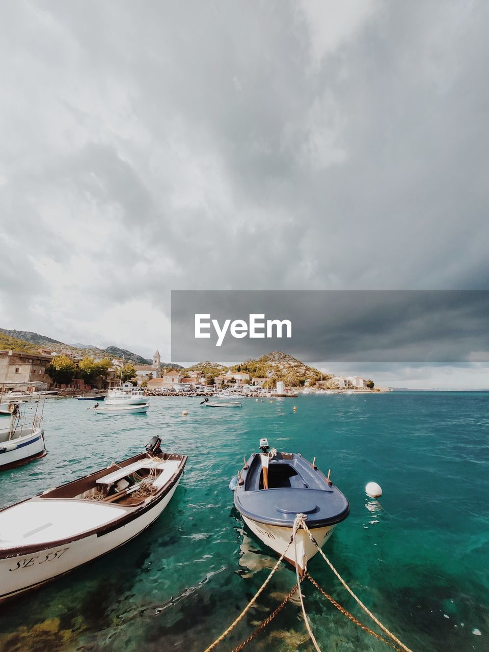 BOATS MOORED ON SEA AGAINST SKY