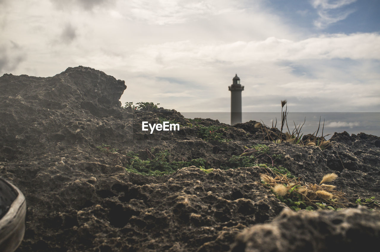 Lighthouse by sea against sky