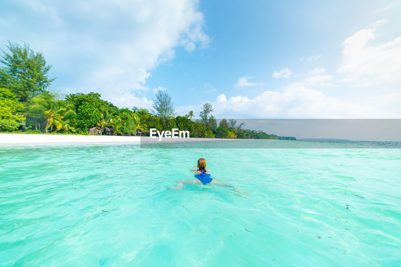 REAR VIEW OF MAN IN SWIMMING POOL