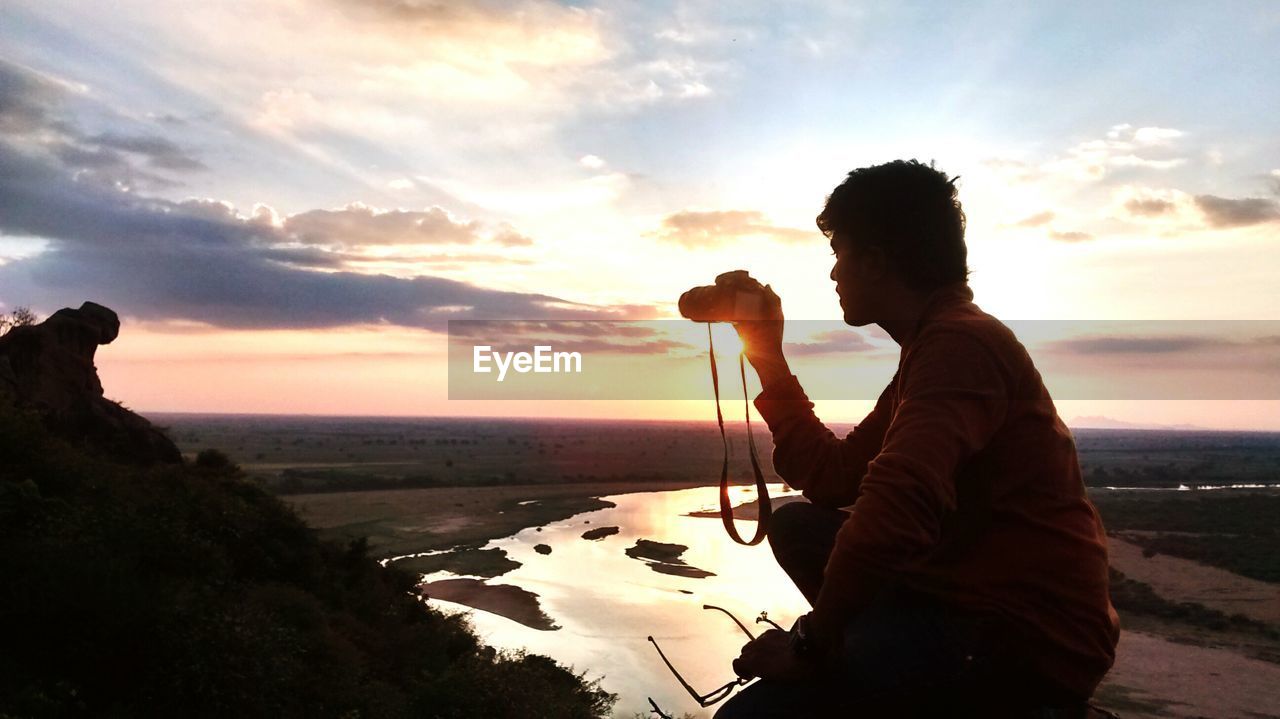 Man taking photo at sunset