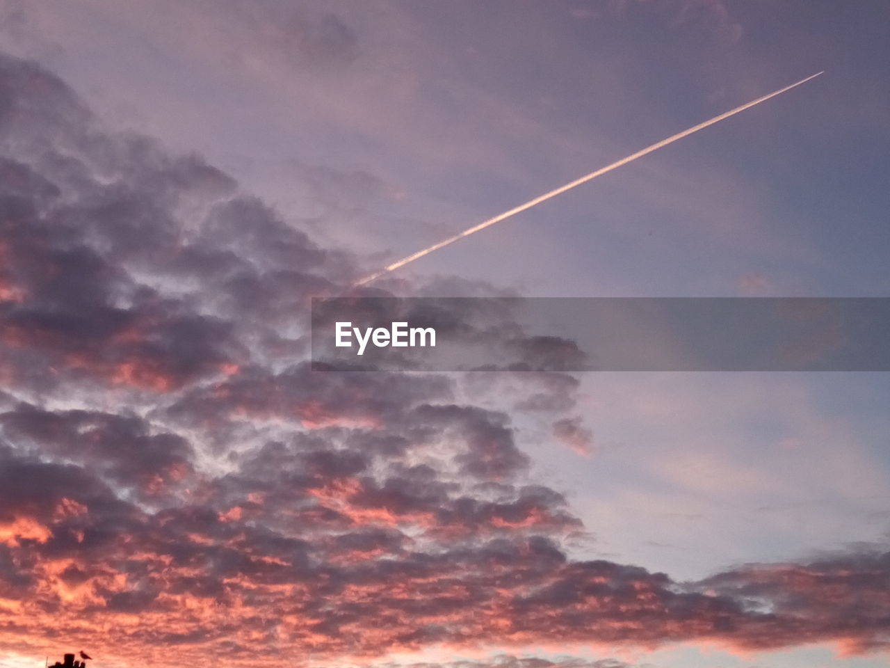 LOW ANGLE VIEW OF VAPOR TRAILS IN SKY DURING SUNSET