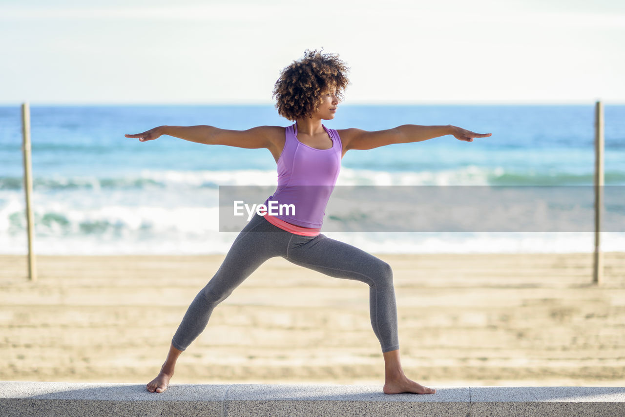 Full length of young woman performing yoga outdoors