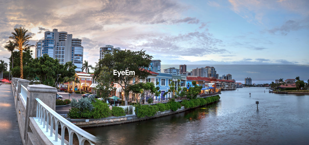 Christmas lights at sunset over the colorful shops of the village on venetian bay in naples, florida