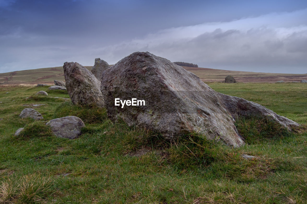 Rocks on field against sky