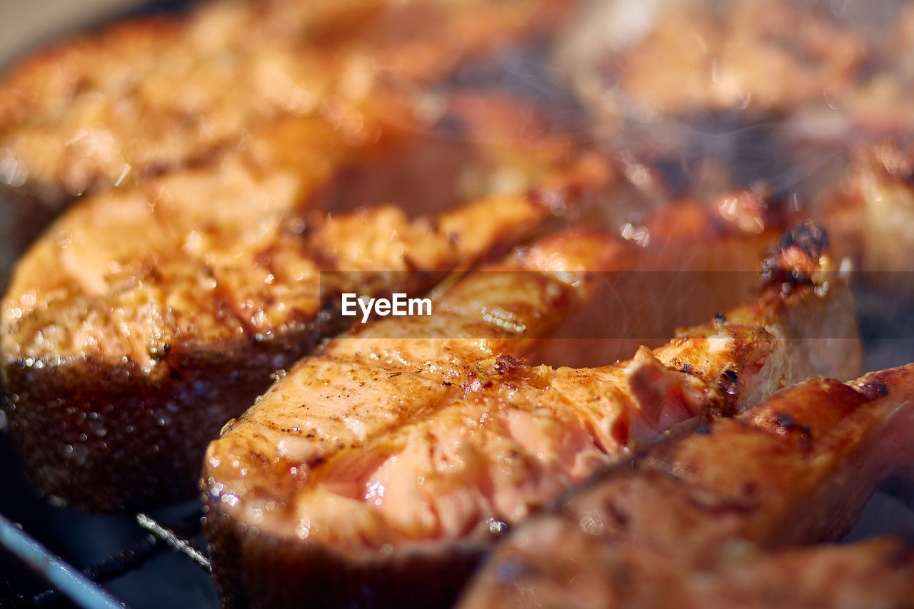 CLOSE-UP OF MEAT COOKING ON BARBECUE