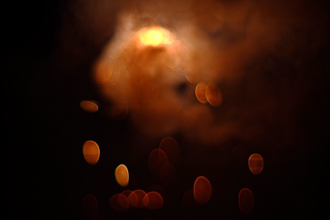 Defocused image of illuminated lights and smoke at night
