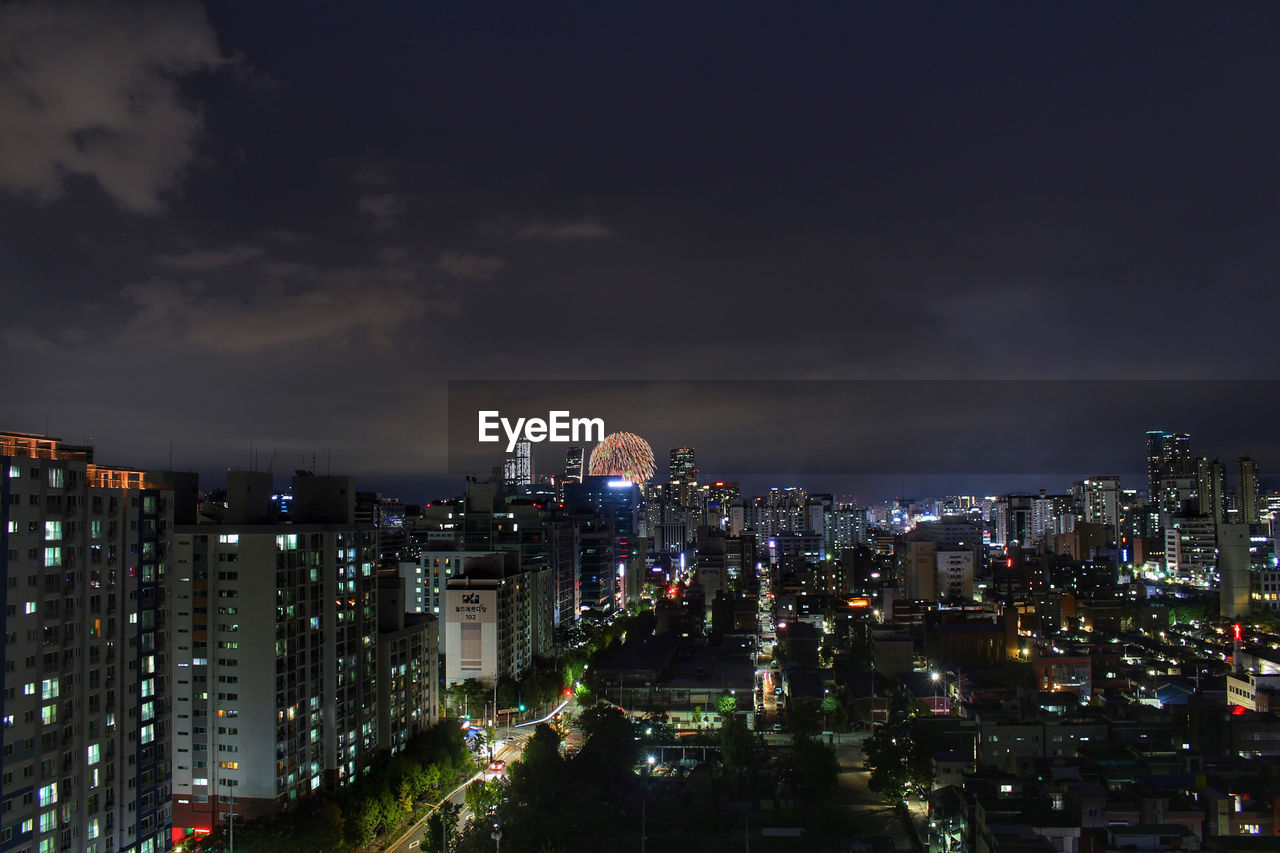 Illuminated cityscape against sky at night