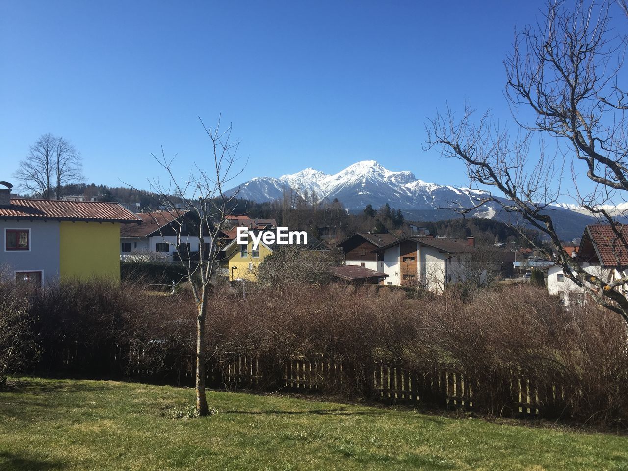 Houses by snowcapped mountain against sky