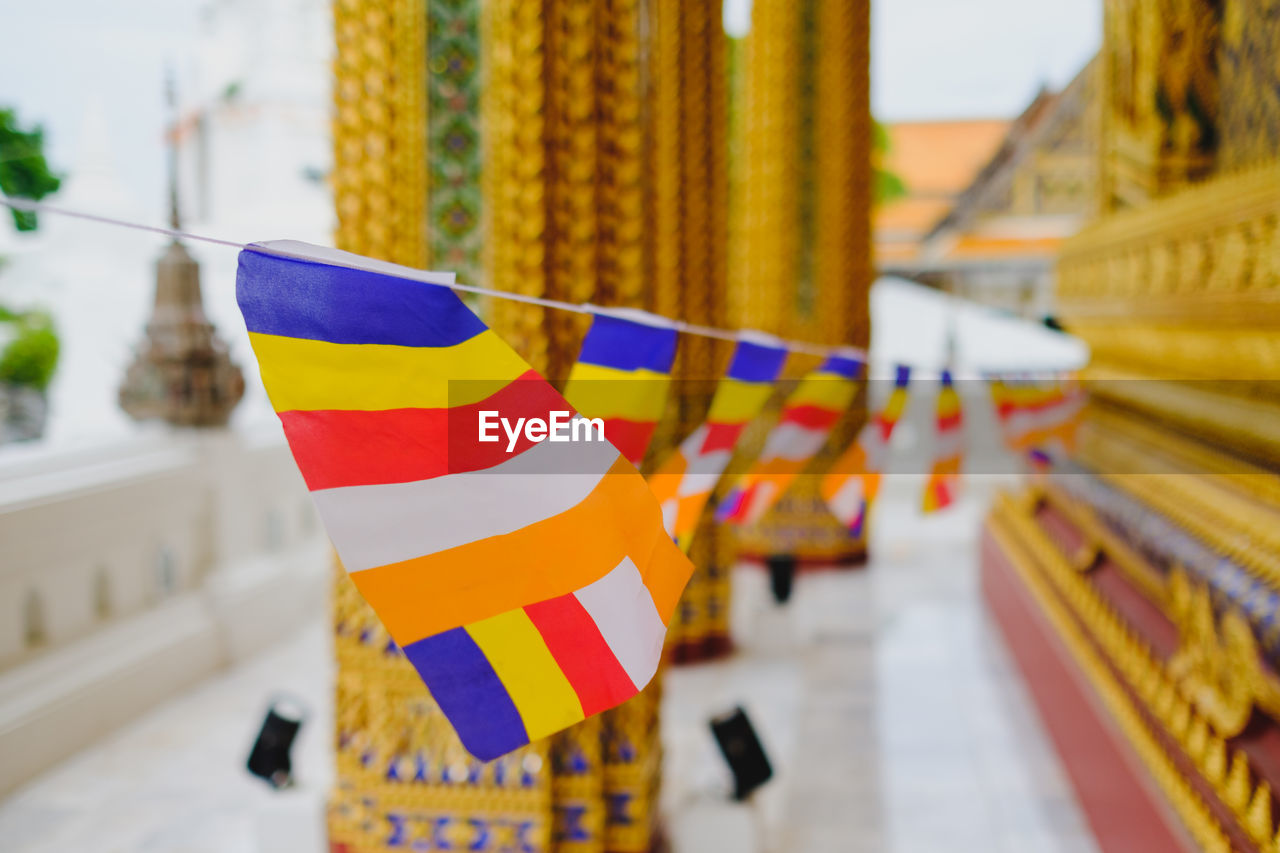 Close-up of multi colored buddhist flags hanging outside building