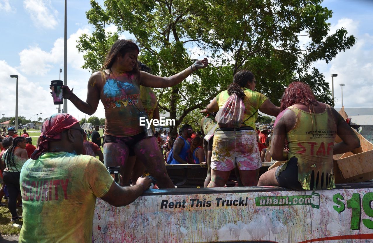 REAR VIEW OF PEOPLE AGAINST TREE