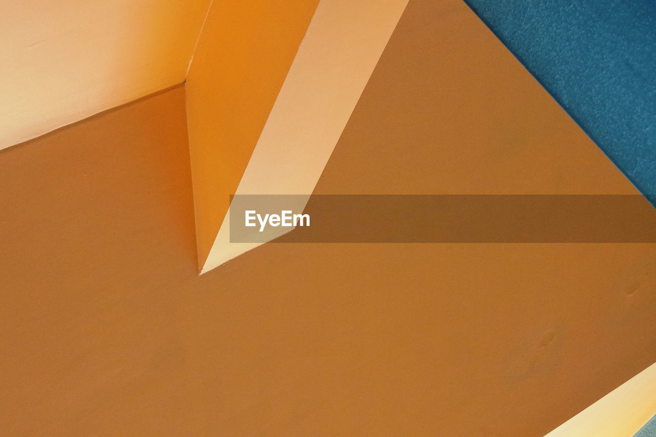 HIGH ANGLE VIEW OF ORANGE WALL AND PAPER