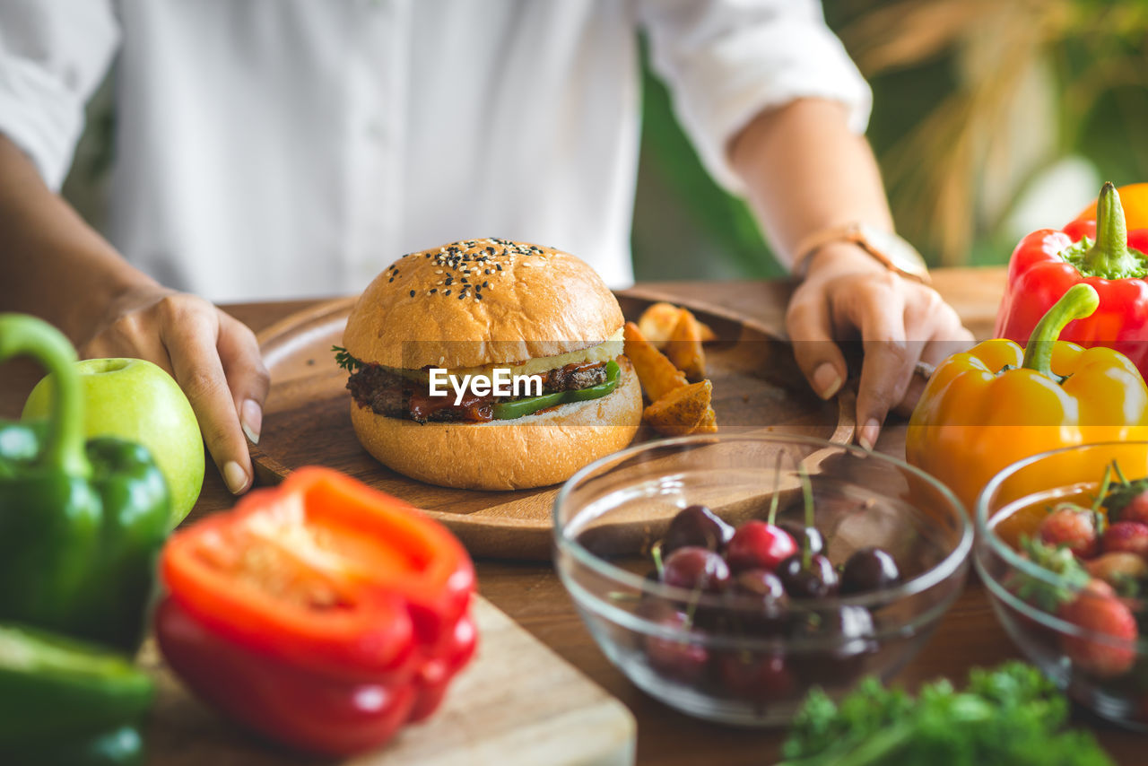 Close-up of woman with burger on table