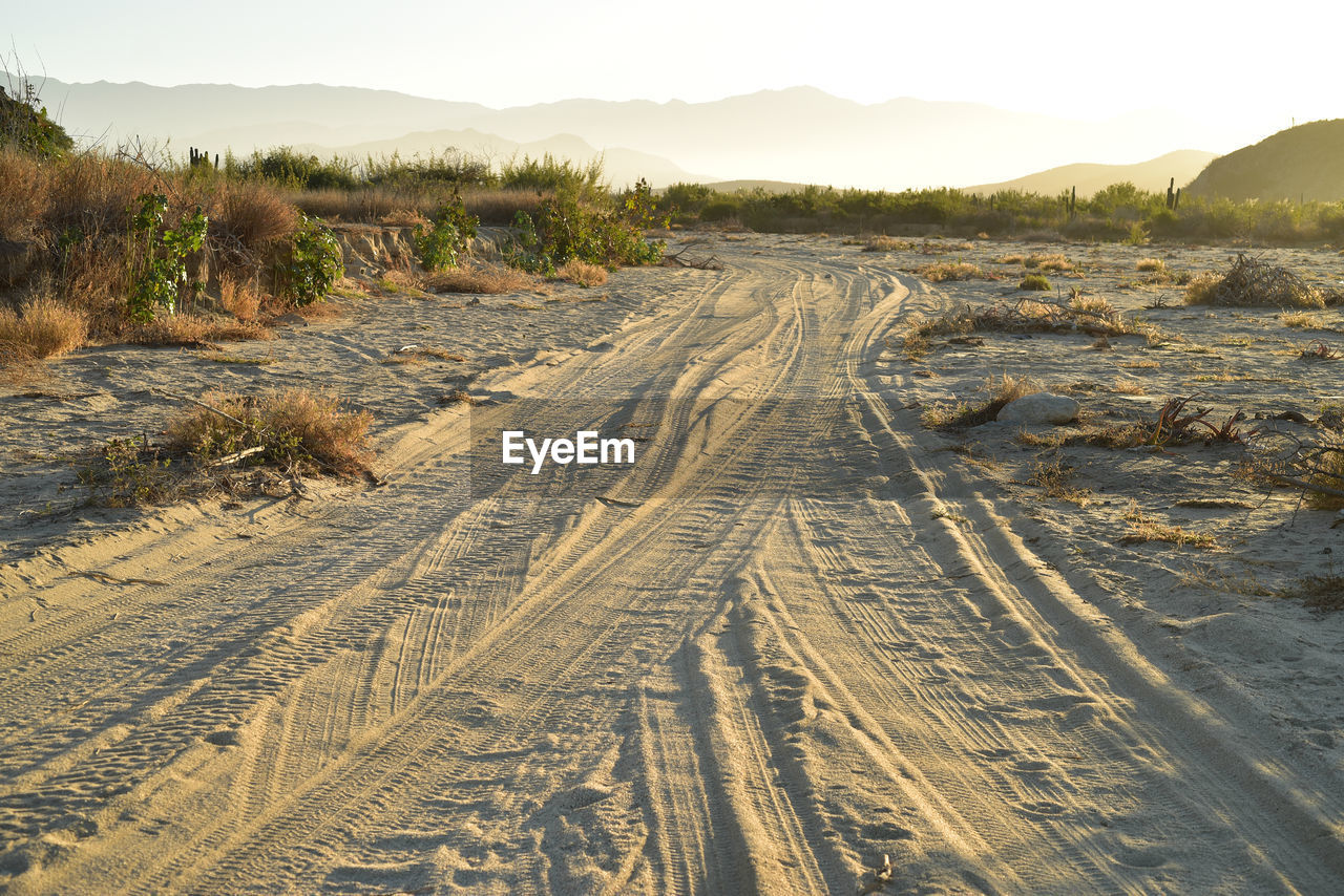 Panoramic view of dirt road on land against sky