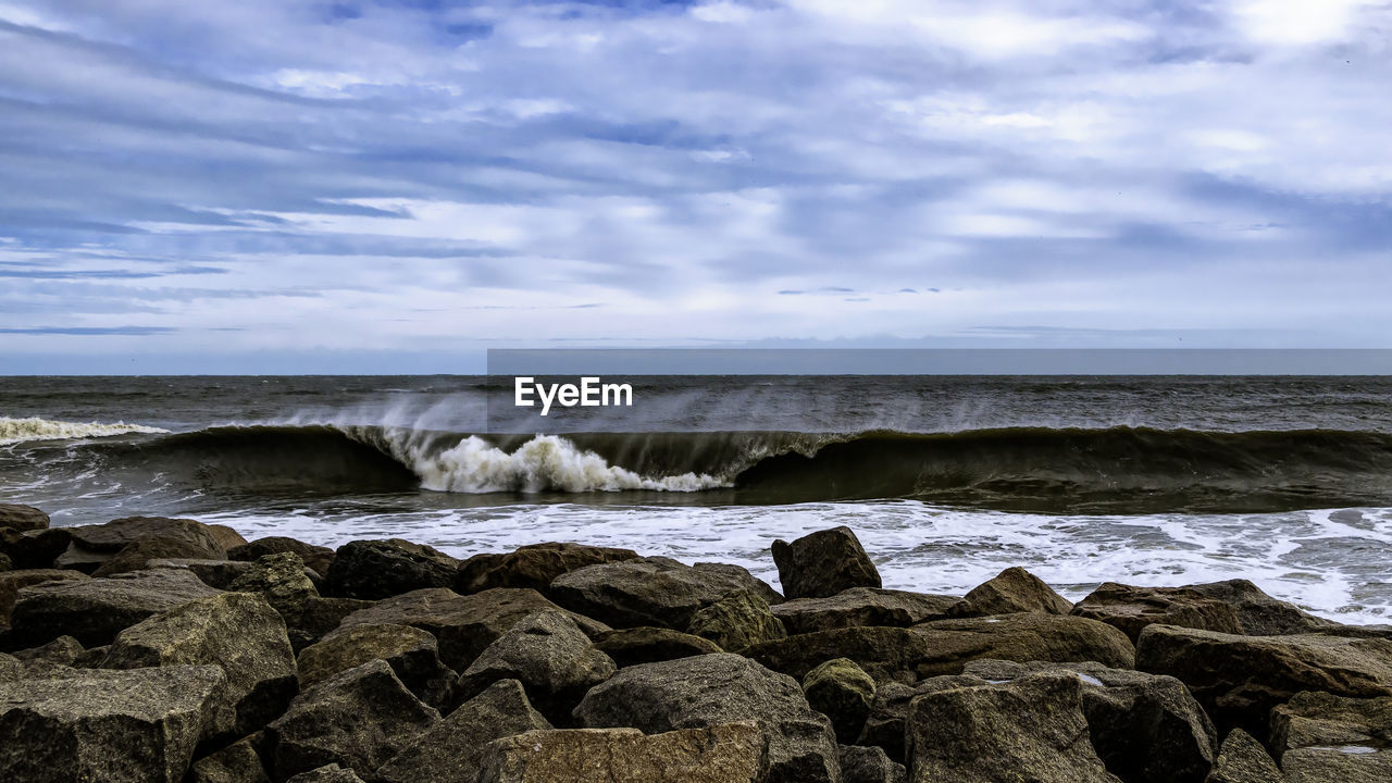 ROCKS ON SEA SHORE AGAINST SKY