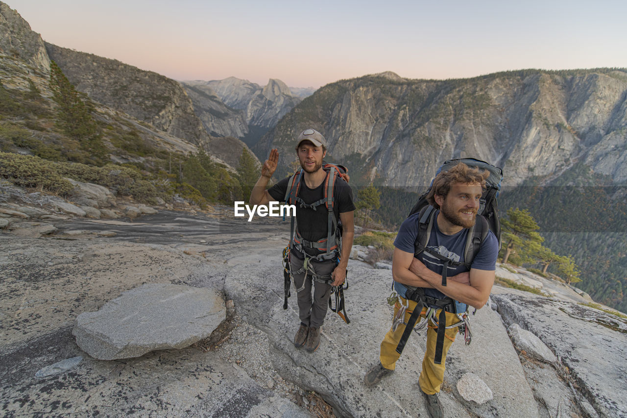 Two hikers at the top of el capitan in yosemite valley at sunset