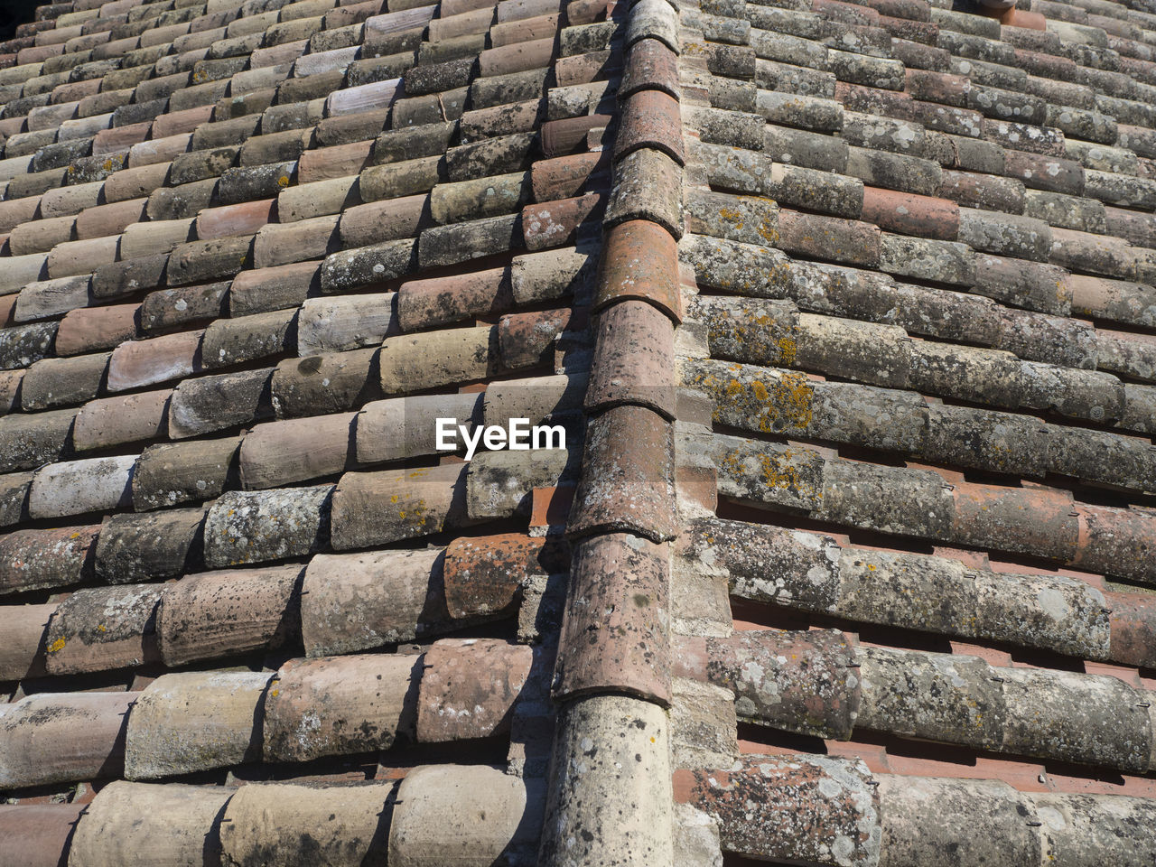 LOW ANGLE VIEW OF BRICK WALL WITH STONE ROOF