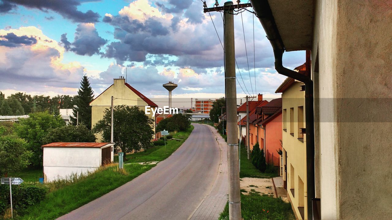 EMPTY ROAD ALONG BUILT STRUCTURES AND PLANTS