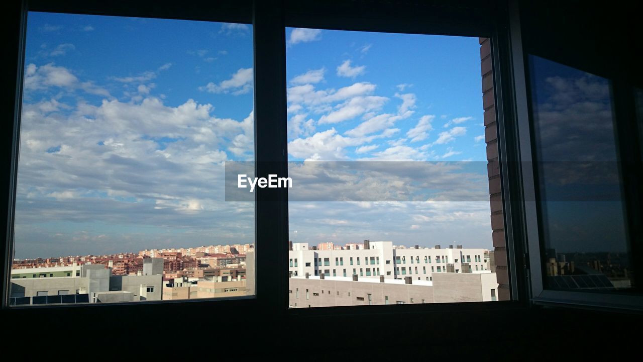 City against sky seen through home window