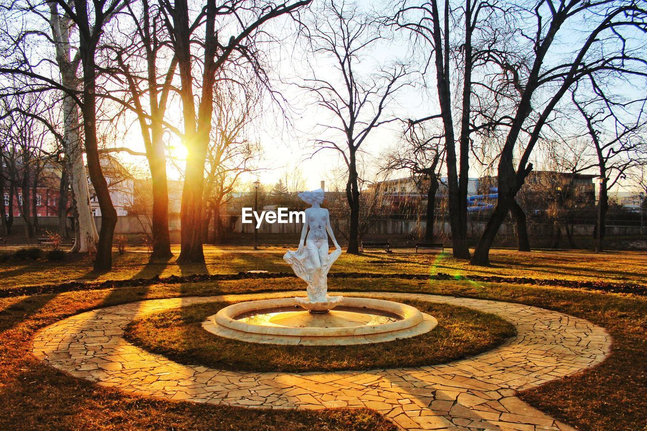 REAR VIEW OF WOMAN STANDING AT PARK