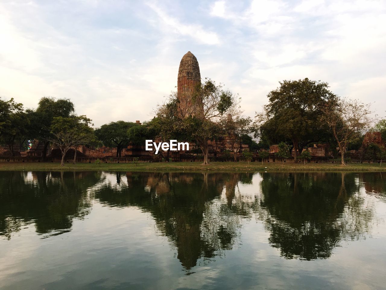 Historic temple by lake against sky