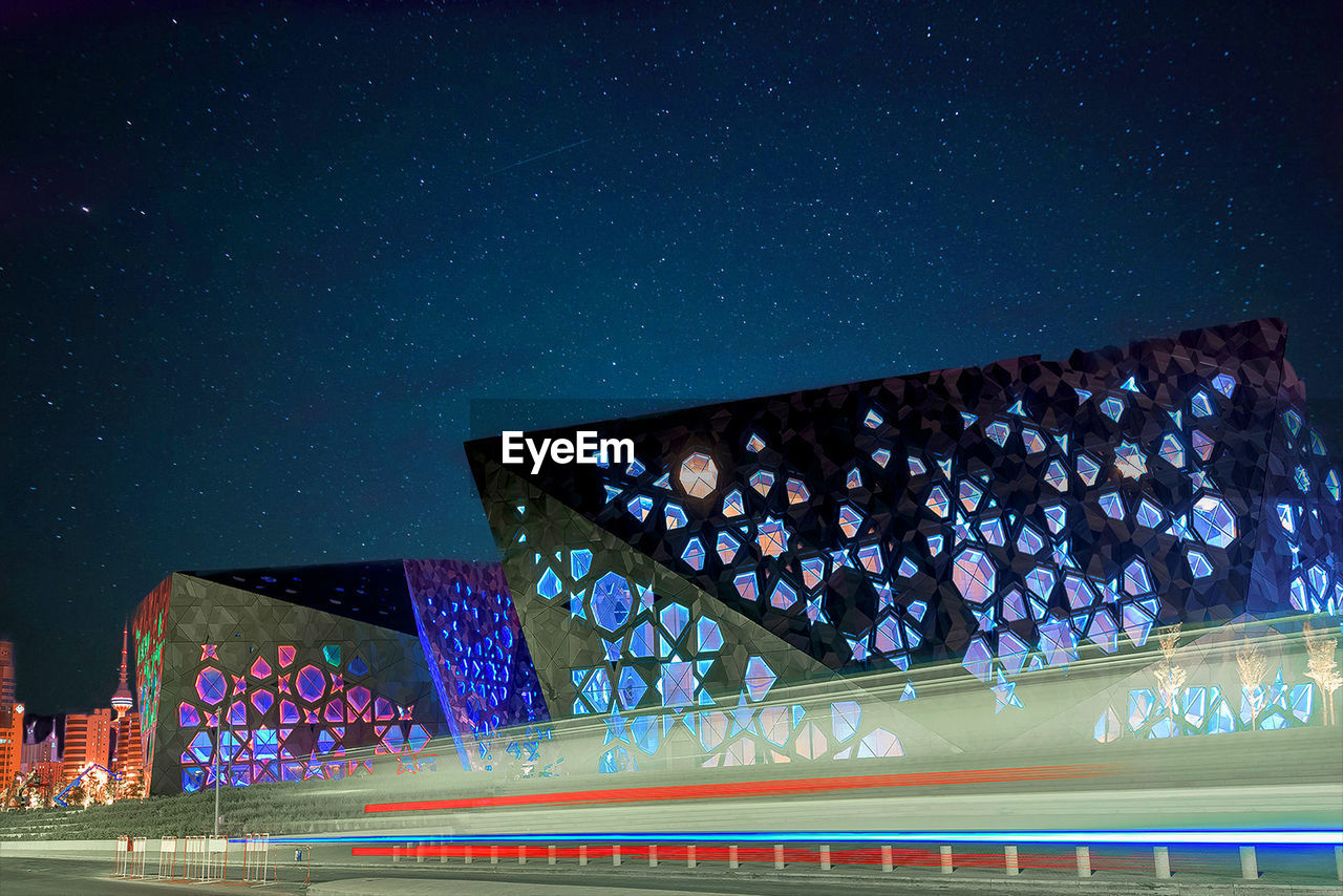 Low angle view of illuminated bridge against sky at night