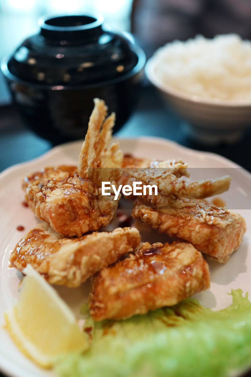 Close-up of deep fried salmon served in plate on table at home