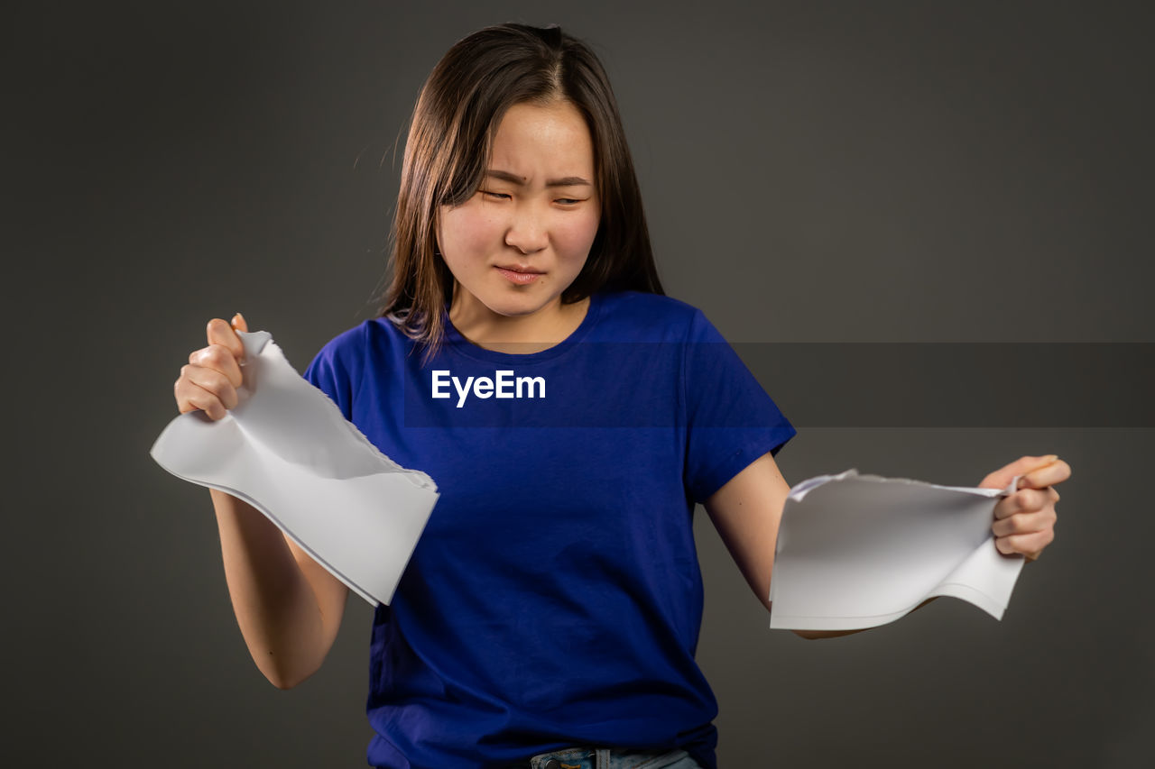 CUTE GIRL HOLDING PAPER AGAINST BLACK BACKGROUND