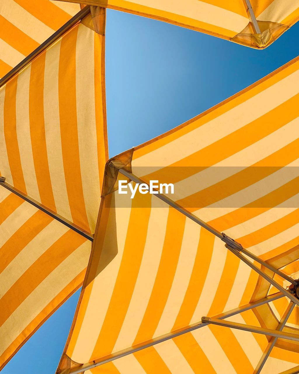 Low angle view of yellow parasol against clear sky