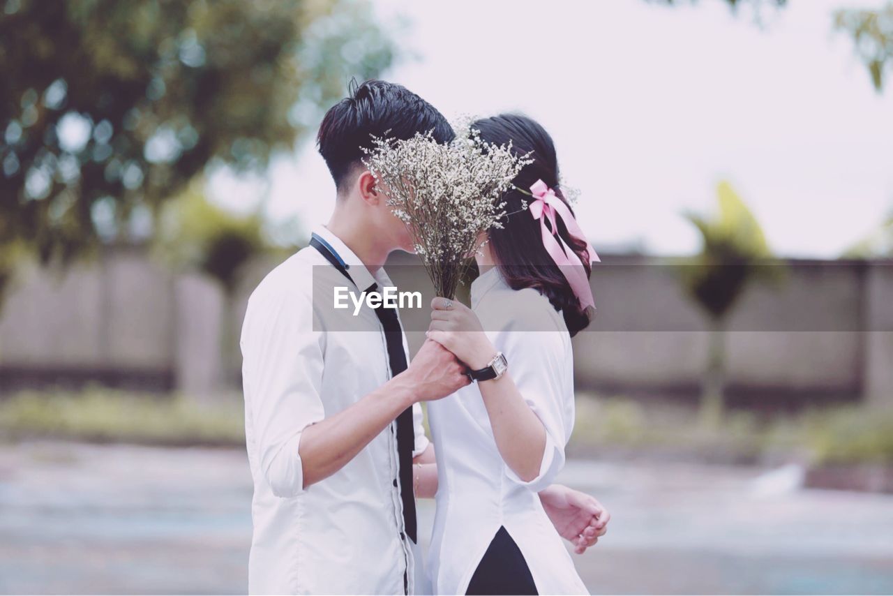 Side view of couple holding bouquet
