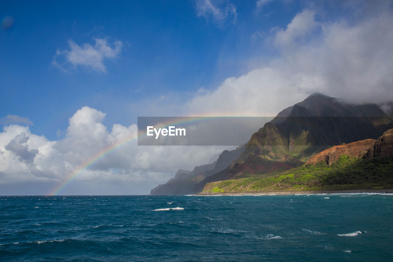 Scenic view of sea against sky with rainbow. na pali coast, kauai, hawaii