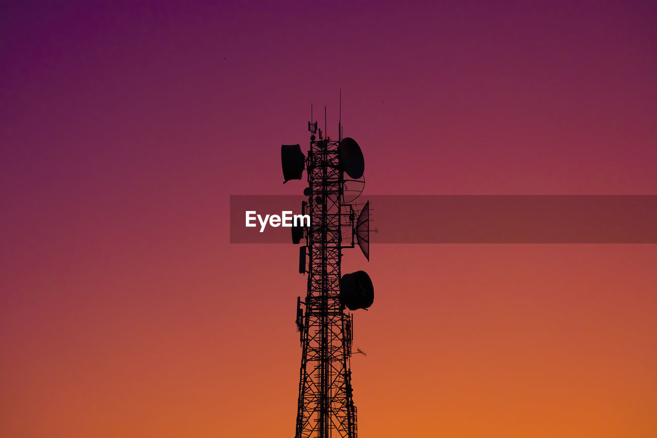 Low angle view of communications tower against clear sky during sunset