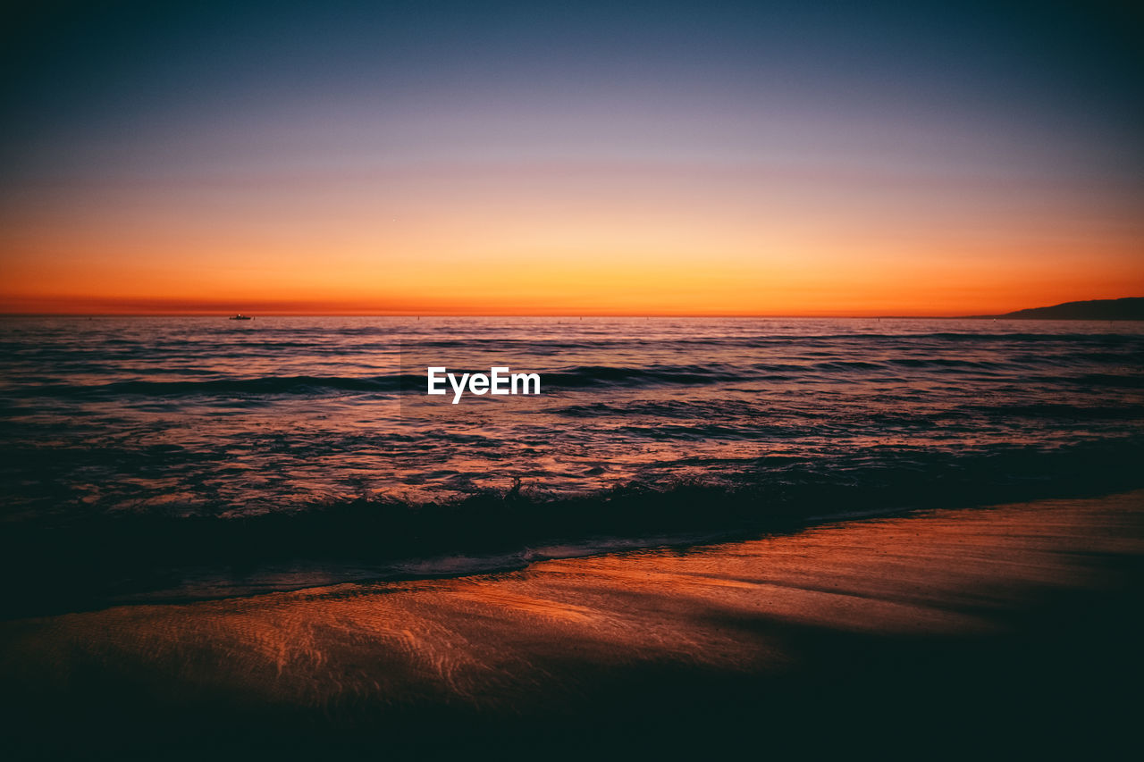 Scenic view of sea against romantic sky at sunset