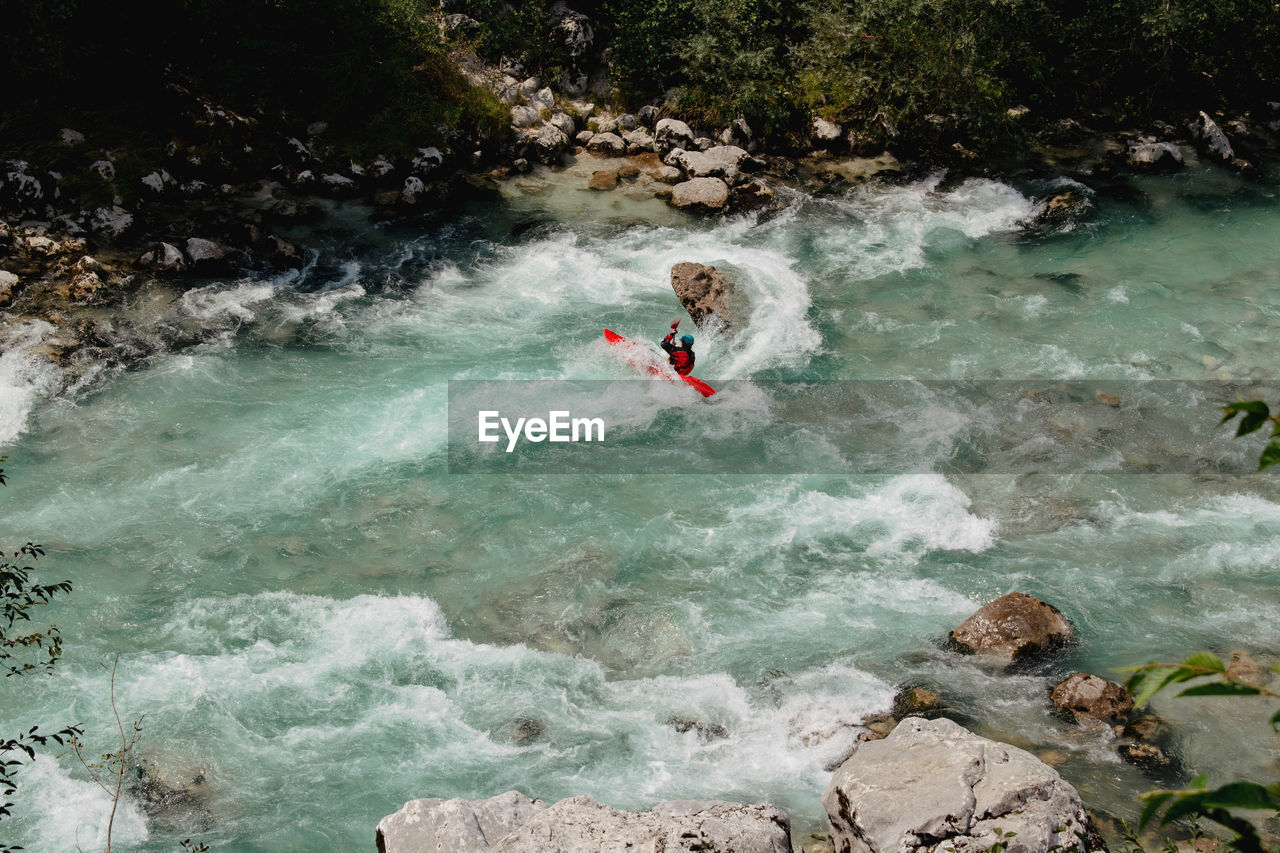 Man kayaking on the soca river with emerald color in slovenia
