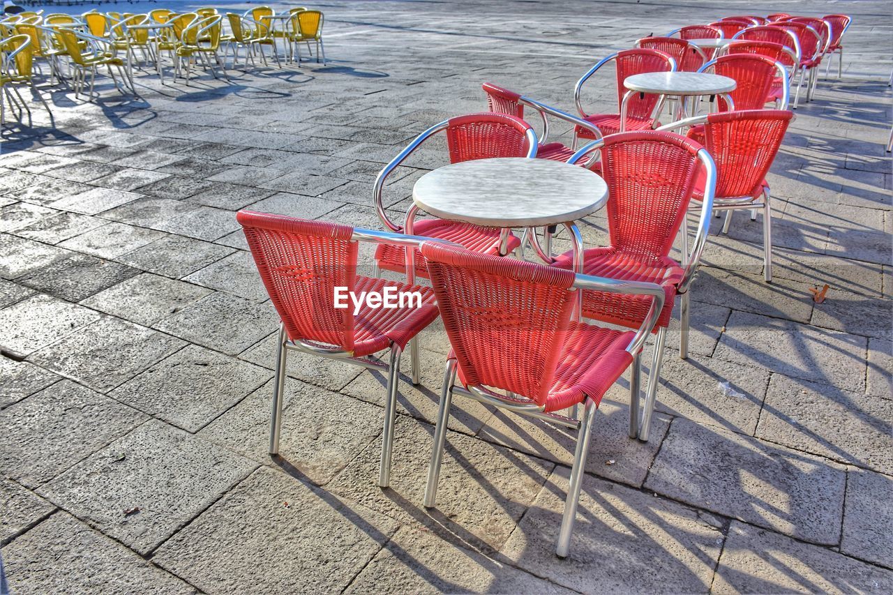 High angle view of empty chairs and table at sidewalk cafe