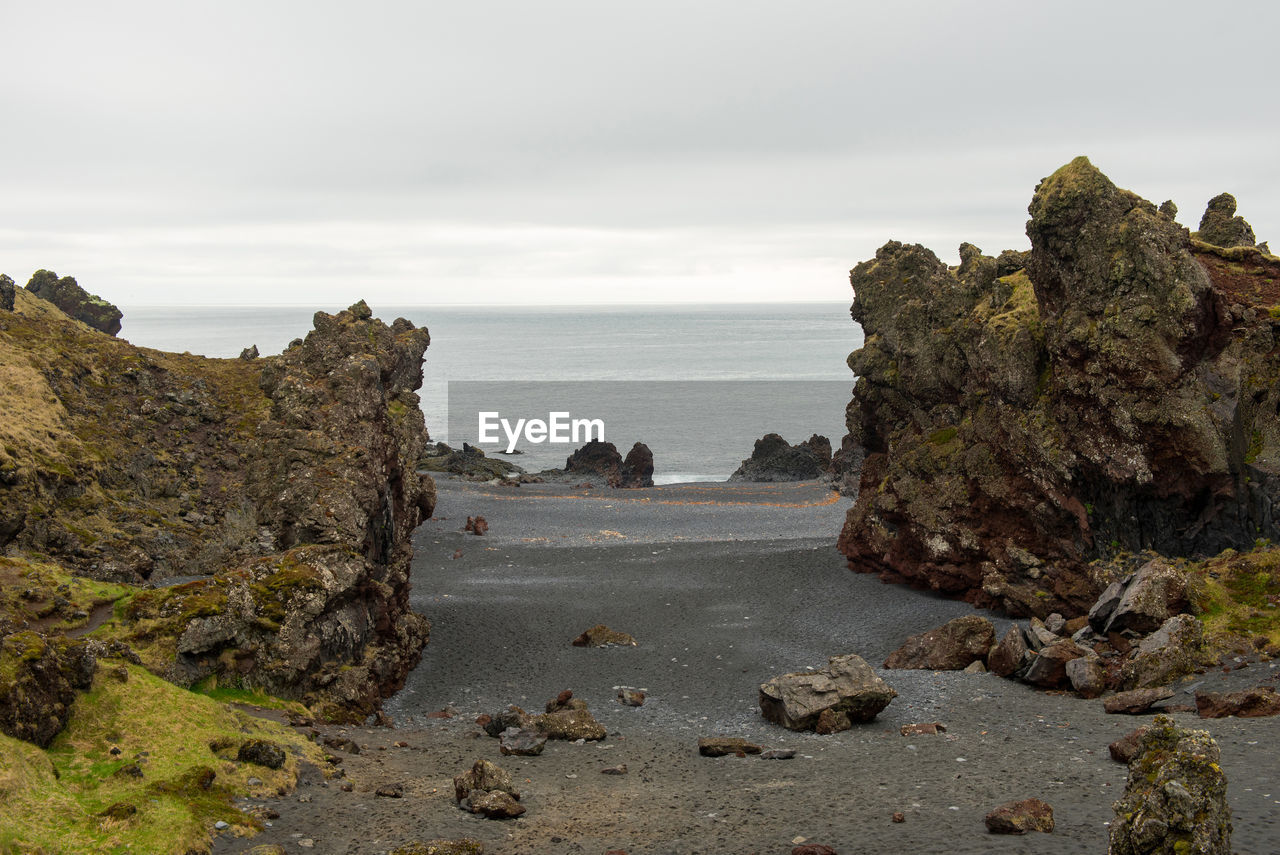 Scenic view of rocks on beach against sky