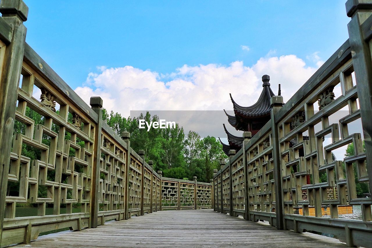 Footbridge at temple against sky