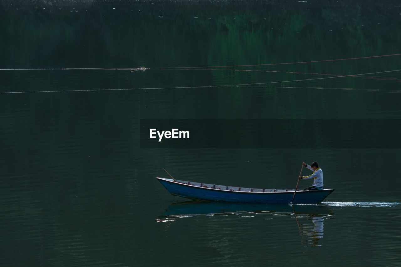 MAN SAILING IN LAKE