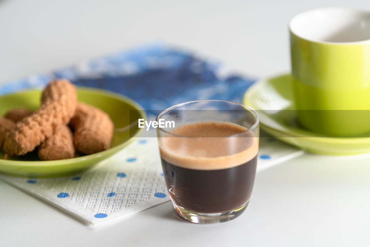 Close-up of espresso in cup by food on table