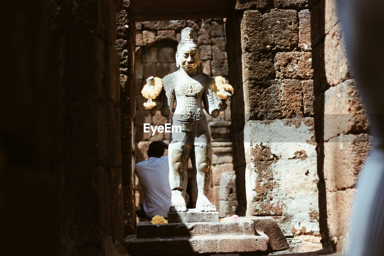 FULL LENGTH OF YOUNG WOMAN STANDING ON WALL